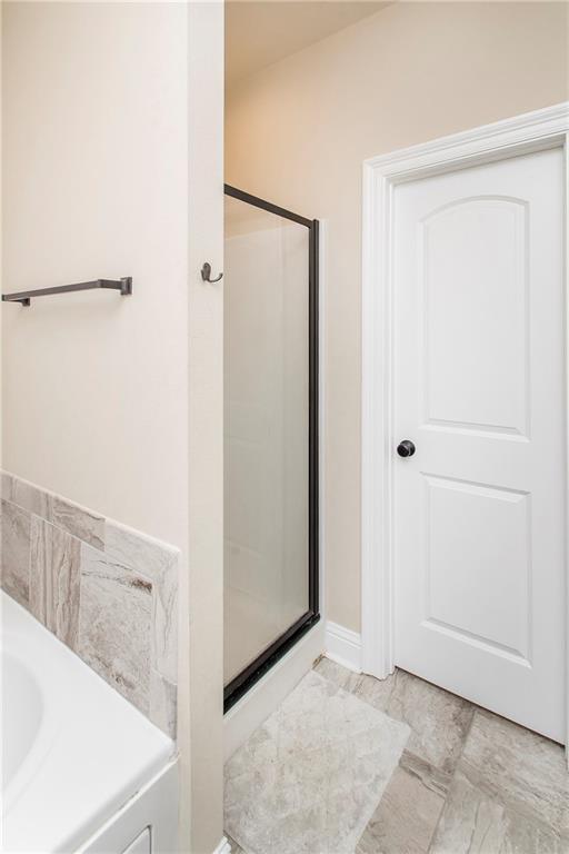 20291 Clemson Way, Ponchatoula, LA 70454 - bathroom with a stall shower and marble look tile flooring