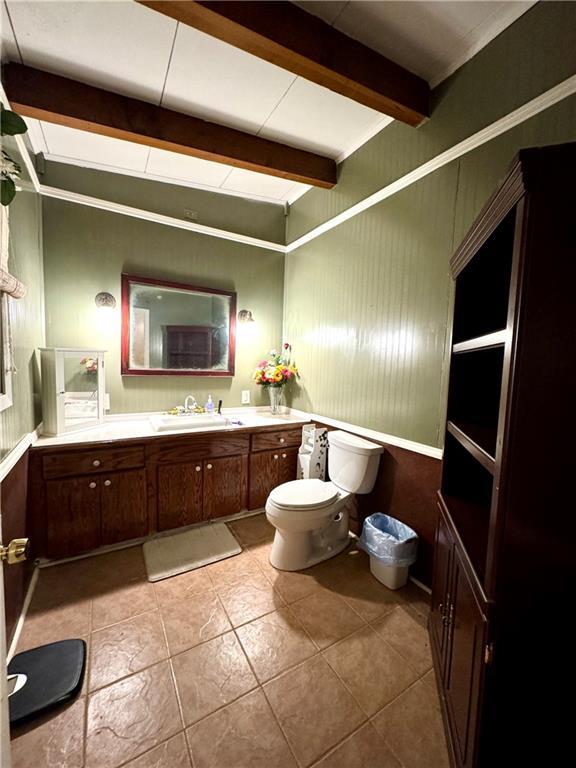 bathroom with beam ceiling, tile patterned floors, vanity, and toilet