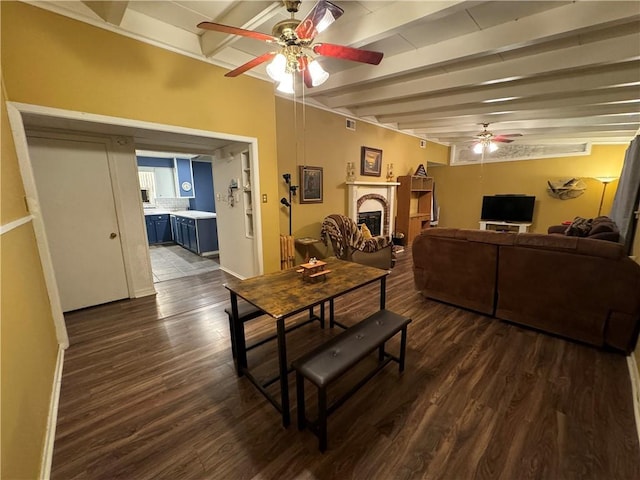 dining space featuring beamed ceiling, dark hardwood / wood-style floors, and ceiling fan