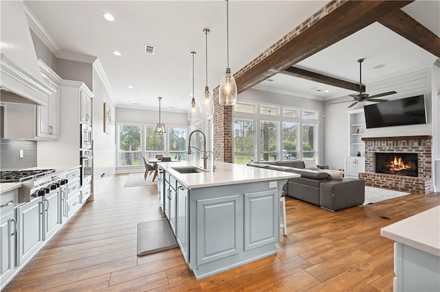 kitchen featuring plenty of natural light, decorative light fixtures, an island with sink, and appliances with stainless steel finishes