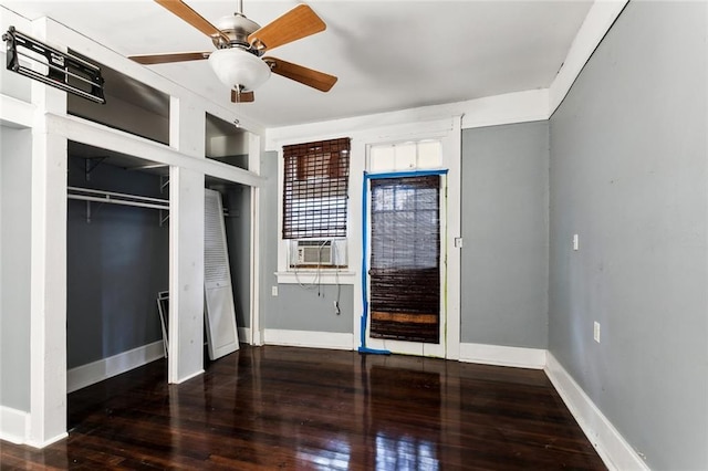 unfurnished bedroom with ceiling fan and dark wood-type flooring