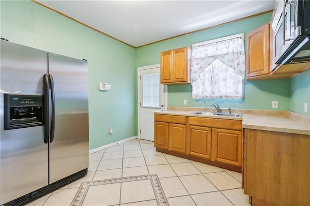 kitchen featuring light tile patterned floors, stainless steel appliances, and sink