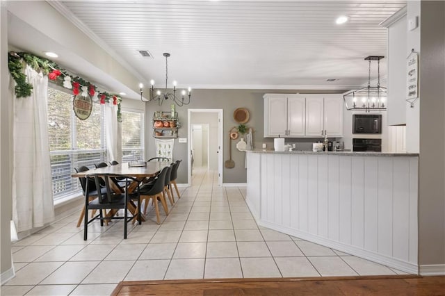 kitchen with white cabinets, pendant lighting, a wealth of natural light, and black appliances