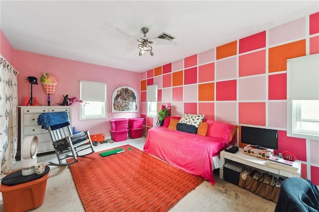 carpeted bedroom featuring ceiling fan and multiple windows