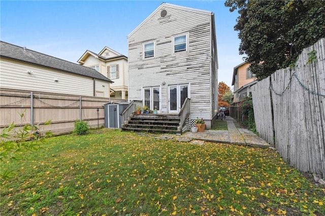 rear view of house with a lawn and a storage shed