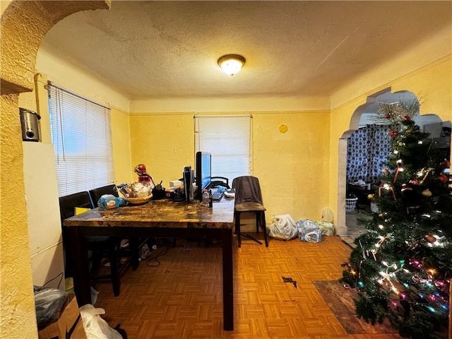 office area featuring parquet flooring and a textured ceiling