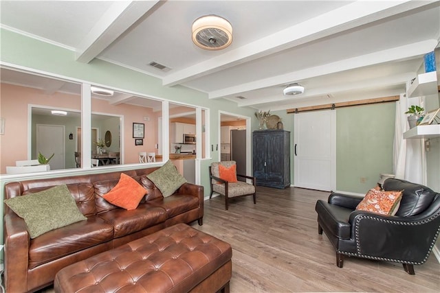 living room featuring beam ceiling, a barn door, and hardwood / wood-style floors