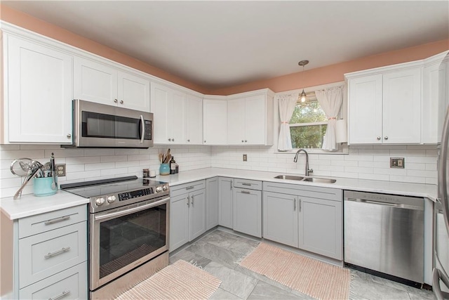 kitchen with backsplash, decorative light fixtures, sink, and stainless steel appliances