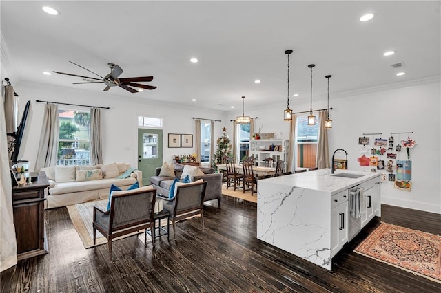 kitchen with pendant lighting, a center island with sink, light stone countertops, dark hardwood / wood-style flooring, and white cabinetry