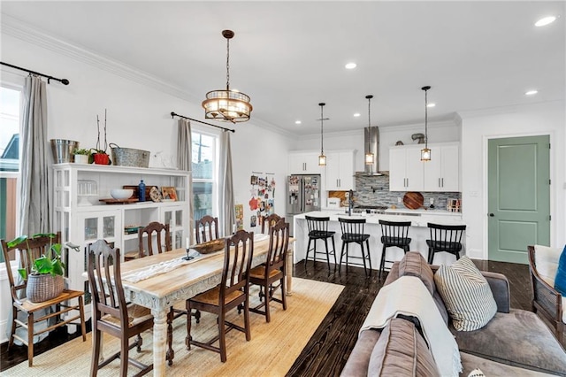 dining room with light hardwood / wood-style floors, crown molding, and a notable chandelier