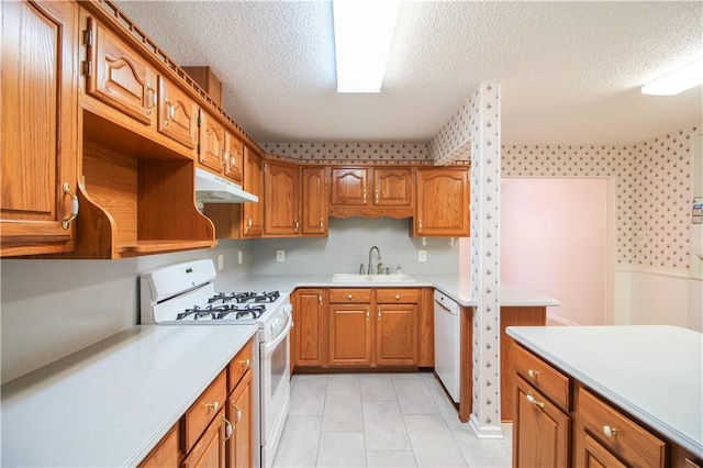 kitchen featuring a textured ceiling, white appliances, light tile patterned floors, and sink