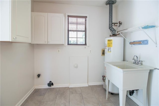 washroom featuring cabinets, sink, light tile patterned flooring, and water heater