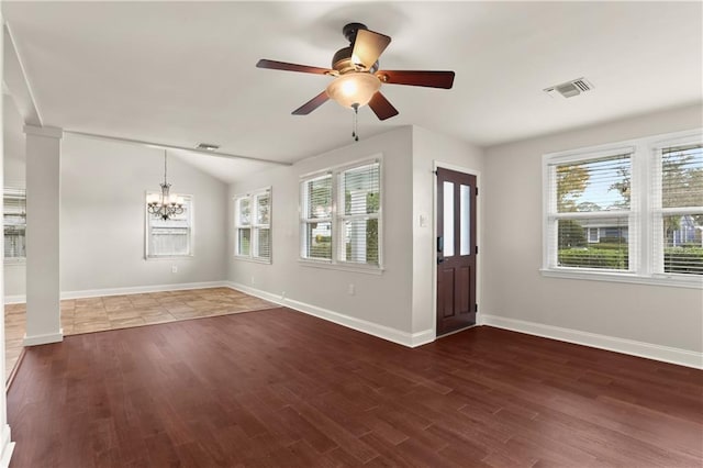 spare room with a healthy amount of sunlight, dark wood-type flooring, and vaulted ceiling