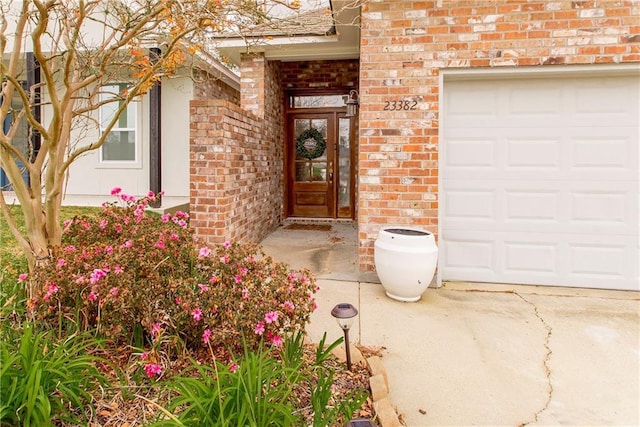 doorway to property featuring brick siding and a garage