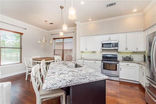 kitchen with visible vents, decorative backsplash, stainless steel appliances, and a sink