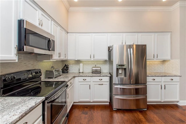 kitchen featuring light stone counters, crown molding, stainless steel appliances, and white cabinetry