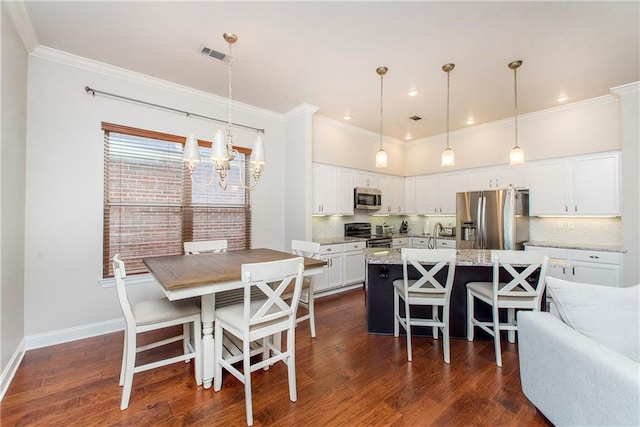 dining room featuring dark wood-style floors, visible vents, ornamental molding, baseboards, and a chandelier
