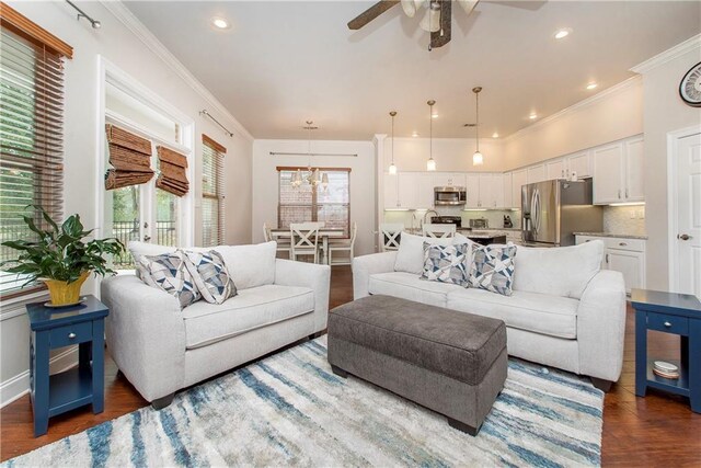 living room with recessed lighting, wood finished floors, crown molding, and ceiling fan with notable chandelier