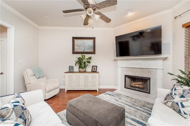 living area featuring a fireplace with flush hearth, wood finished floors, and ornamental molding