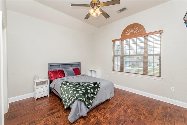 bedroom featuring visible vents, baseboards, lofted ceiling, wood finished floors, and ceiling fan