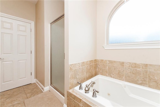 bathroom featuring tile patterned floors, a stall shower, and a tub with jets