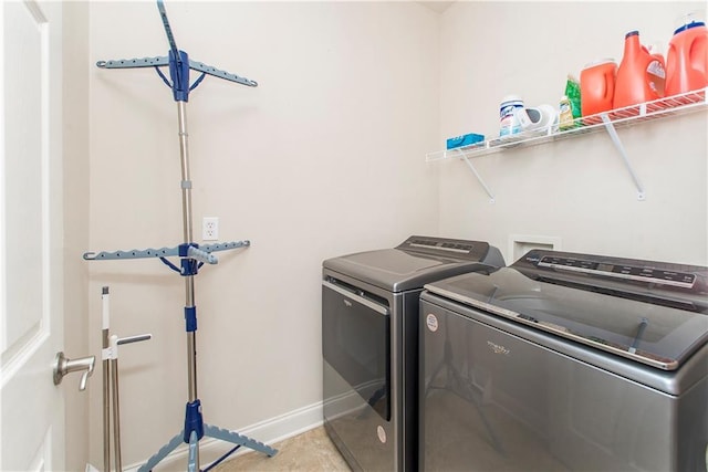 washroom featuring washer and dryer, baseboards, and laundry area