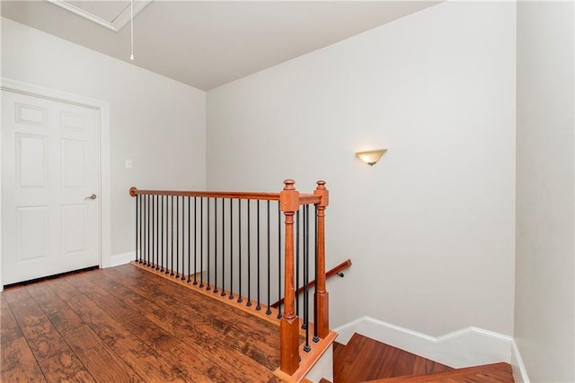 stairs with attic access, baseboards, and wood finished floors