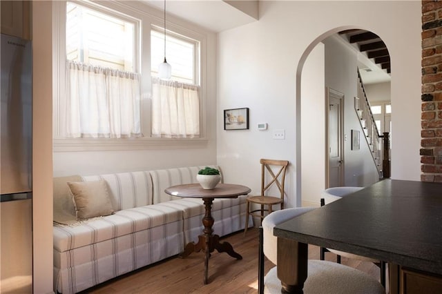 interior space featuring arched walkways, stairs, and wood finished floors