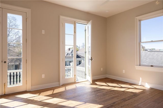 doorway to outside with wood finished floors, french doors, and baseboards