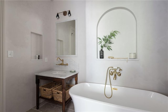 full bathroom with tile patterned flooring, vanity, and a freestanding tub