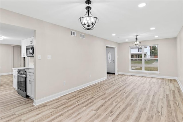 unfurnished living room with light hardwood / wood-style floors and an inviting chandelier