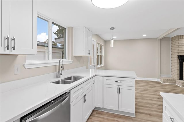 kitchen with kitchen peninsula, white cabinets, sink, pendant lighting, and dishwasher