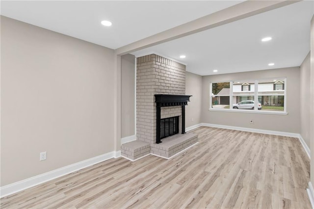 unfurnished living room featuring a fireplace and light hardwood / wood-style floors