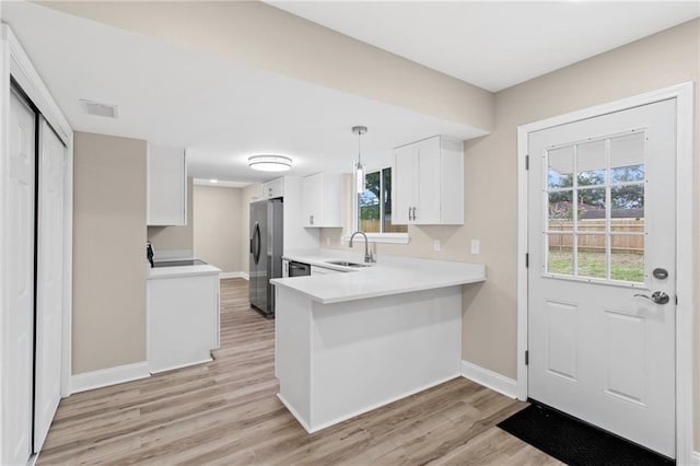 kitchen with white cabinetry, sink, light hardwood / wood-style floors, and appliances with stainless steel finishes