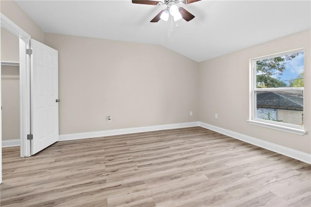 unfurnished bedroom with ceiling fan, a spacious closet, light hardwood / wood-style flooring, a closet, and lofted ceiling