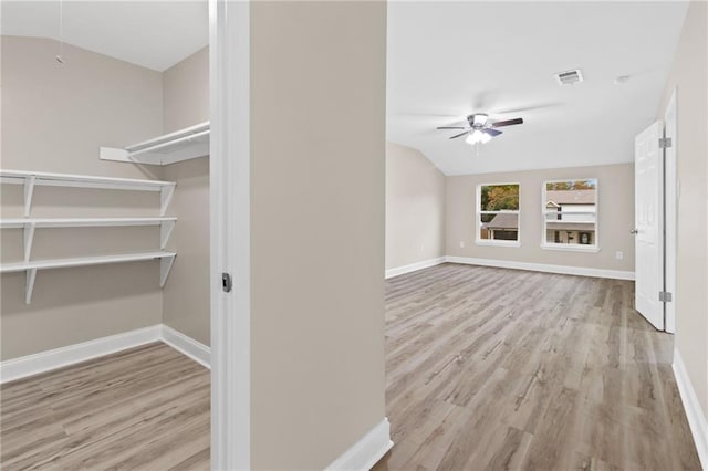 interior space featuring ceiling fan, light wood-type flooring, and vaulted ceiling