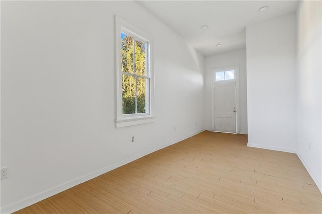 empty room with light hardwood / wood-style flooring and plenty of natural light