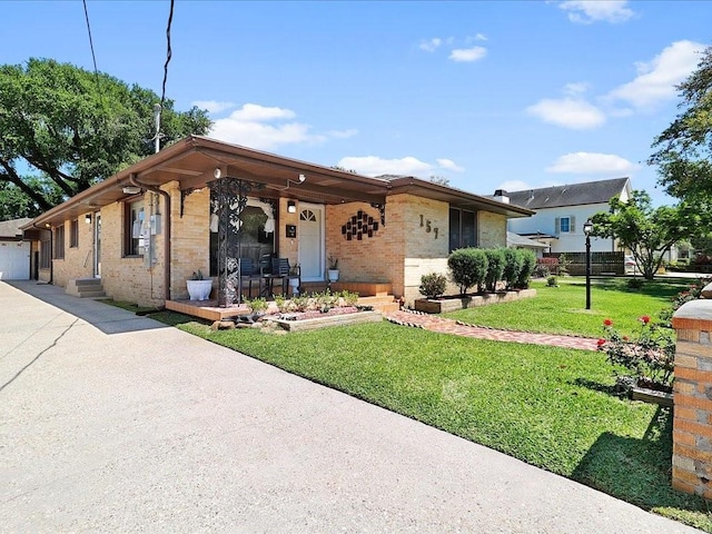 ranch-style house with covered porch and a front lawn