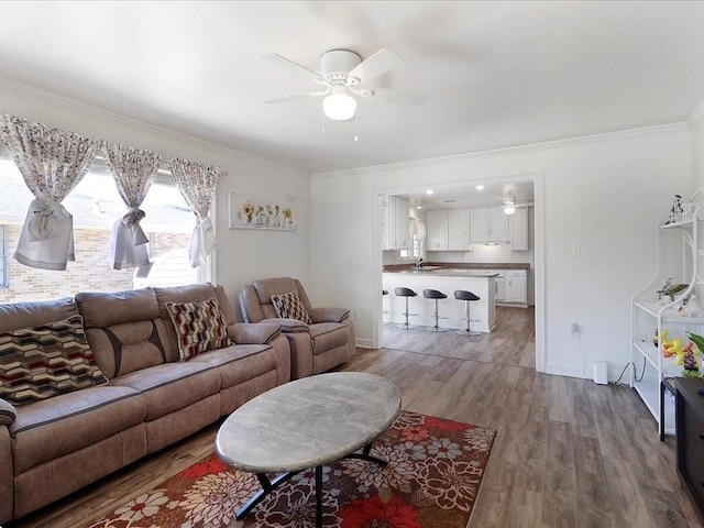 living room featuring hardwood / wood-style floors, ceiling fan, and ornamental molding