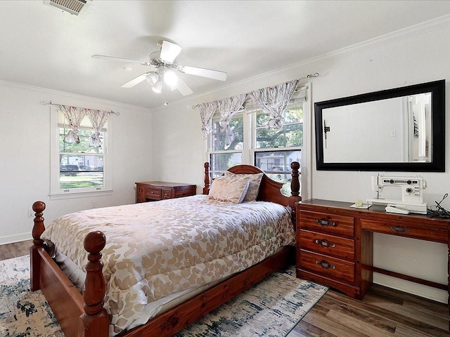 bedroom featuring dark hardwood / wood-style flooring, ceiling fan, and crown molding