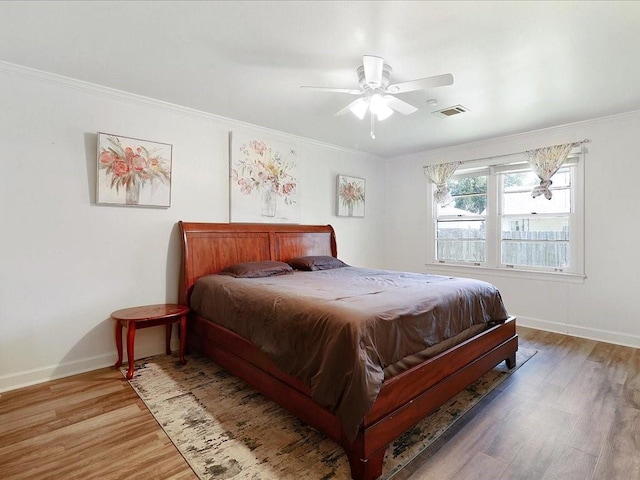 bedroom featuring hardwood / wood-style flooring, ceiling fan, and ornamental molding