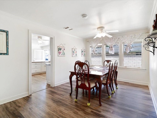 dining space featuring ornamental molding and dark wood-type flooring