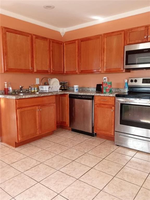 kitchen featuring light tile patterned floors, stainless steel appliances, and light stone counters