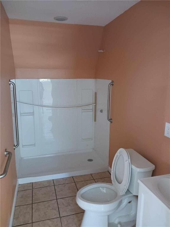 bathroom featuring a shower, tile patterned flooring, vanity, and toilet