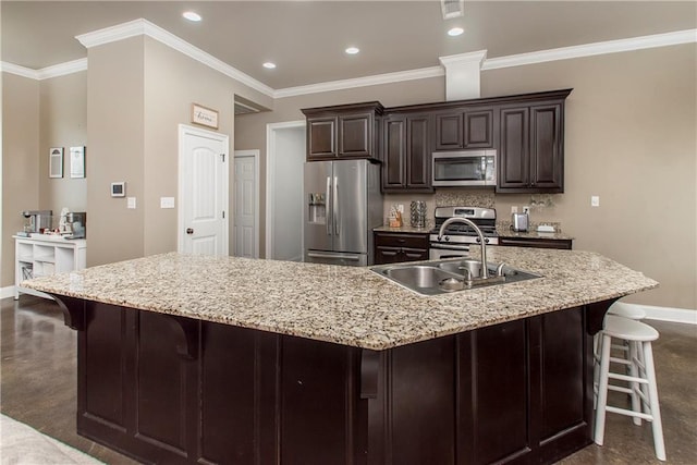 kitchen with a large island with sink, sink, a breakfast bar area, dark brown cabinets, and stainless steel appliances