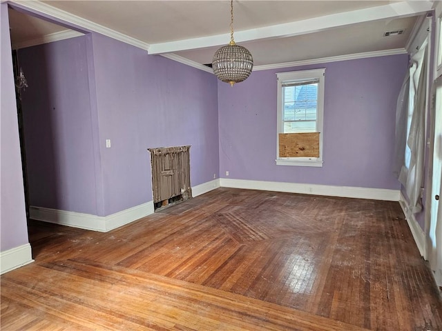 spare room featuring hardwood / wood-style flooring, an inviting chandelier, and ornamental molding