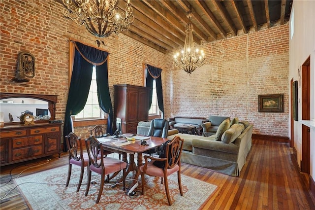 dining room featuring hardwood / wood-style floors, high vaulted ceiling, and brick wall