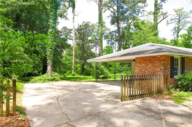 108 N Dr, Covington, LA 70433 - view of car parking with driveway, an attached carport, and fence