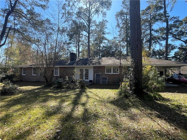 back of property featuring a carport and a yard