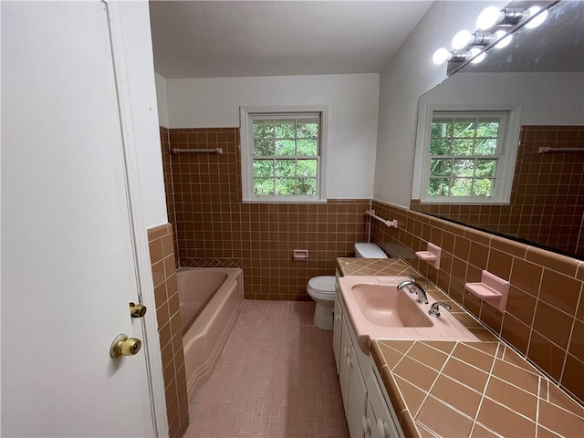 108 N Dr, Covington, LA 70433 - bathroom featuring tile walls, plenty of natural light, toilet, tile patterned floors, and a bath